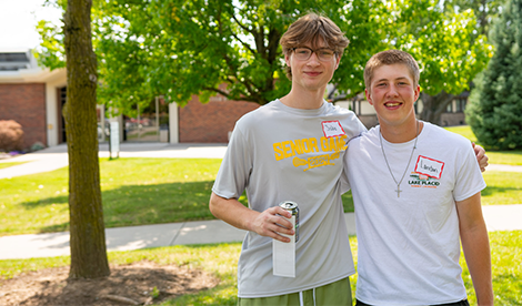 2 students smile on campus