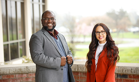 2 students, a man and woman, smile to the camera