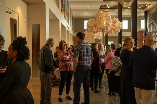 Attendees stand and talk during Dave Basinger's retirement celebration