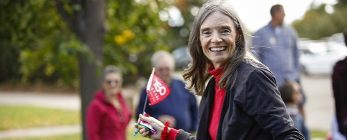 Elvera Berry waves a small flag during the college's 150th anniversary