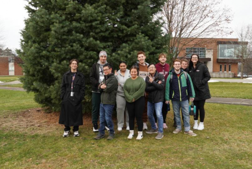 Holly and BELL students stand in front of a tree on campus and smile