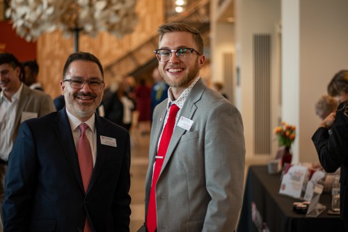 Jason and coworker Kirk wear suits and smile