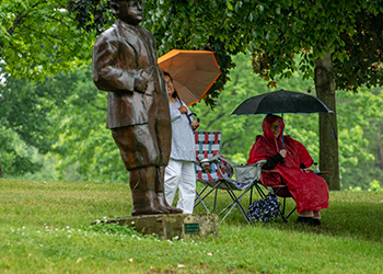 People hold umbrellas on a golf course