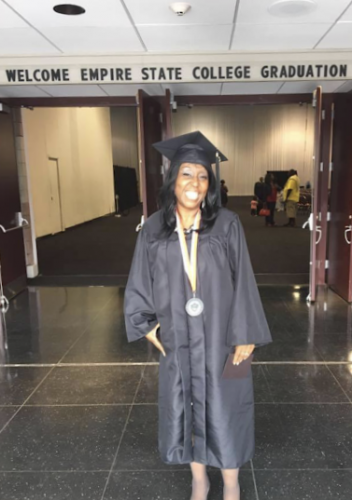 Melinda smiles while wearing cap and gown.