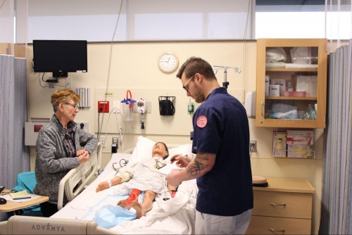 A nursing student works with a patient during a simulation