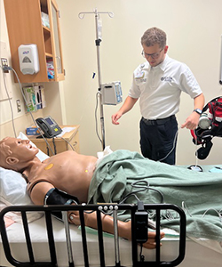 A man works on patient care in the simulation center