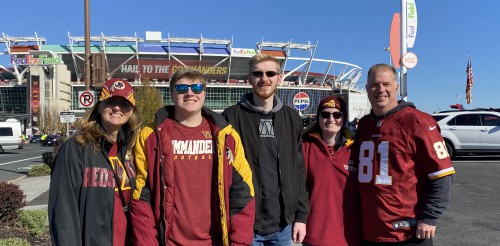 The Ottos smile outside a football stadium