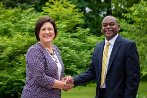 Deana Porterfield and Dr. Hayles shake hands and smile at the camera.