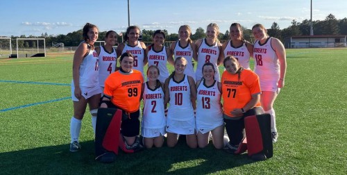 The Roberts field hockey team smiles together after a game.