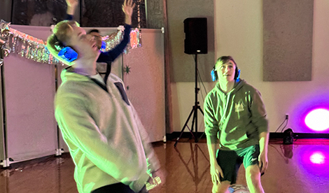 3 young men dance while wearing wireless headphones.