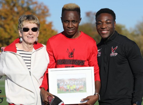 Sue smiles with 2 student athletes.