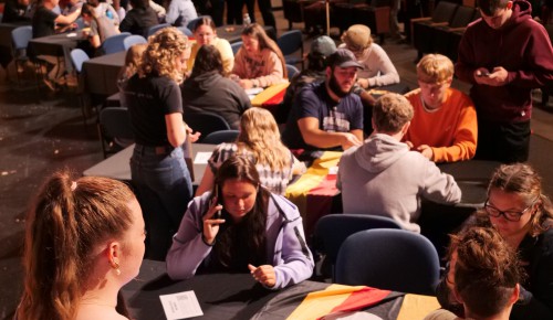 Students sit at tables while other students donate.