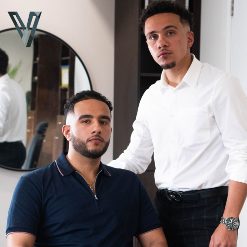 Marc-Anthony Blackburn stands with his hand on his brother's back. They both look to the camera.