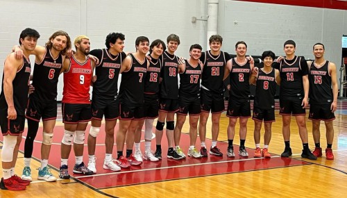 The Roberts men's volleyball team stands and smiles