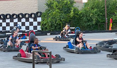 Summer campers drive go carts.