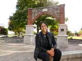 A young woman smiles on campus