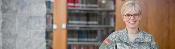 A woman stands in a U.S. military uniform and smiles. 